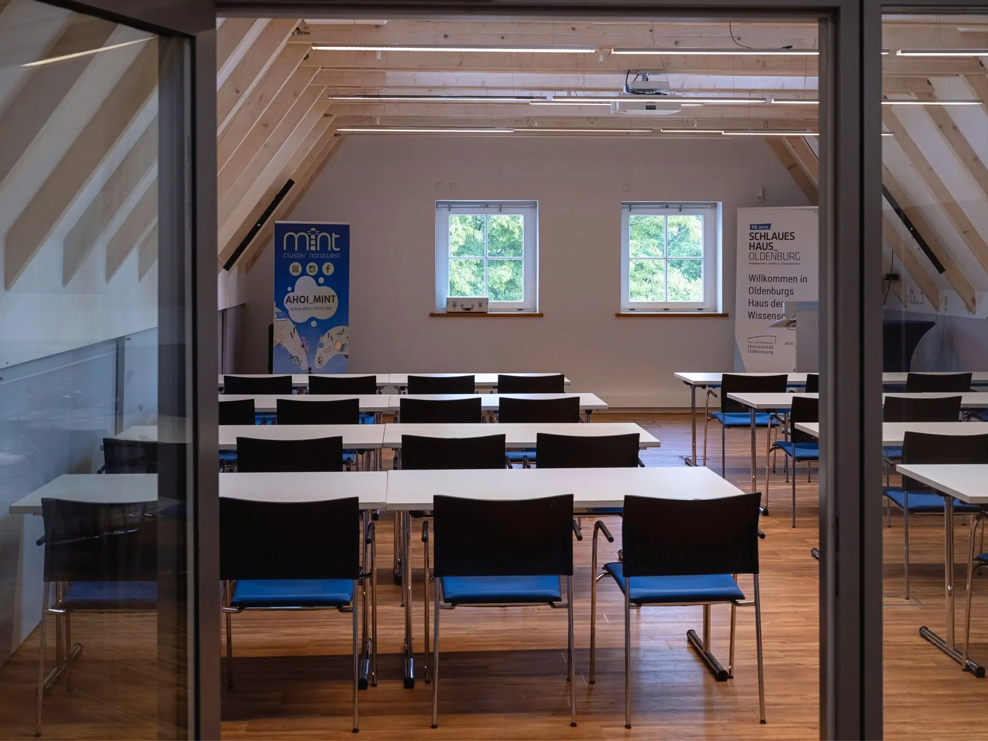 Blick durch die Glastür in Veranstaltungsraum Eins mit Seminarbestuhlung